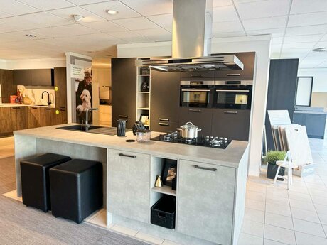 Showroomkeuken Deze sterk afgeprijsde showroomkeuken kun je vinden bij Brugman in Den Haag. Het is een eiland-keuken in de kleur havannazwart / cementgrijs en in de stijl modern. Je profiteert nu van 56% korting, waardoor deze keuken al voor € 9250 van jou kan zijn! Heb je interesse in deze keuken of heb je nog vragen? Bel dan gerust naar <a href="tel:0703477985">0703477985</a> of mail naar <a href="mailto:denhaag@brugman.nl">denhaag@brugman.nl</a>. Je kunt ook vrijblijvend een bezichtiging plannen. Brugman keukens en badkamers Den Haag