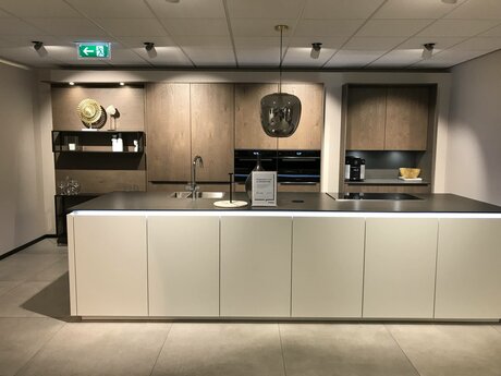 Showroomkeuken Deze sterk afgeprijsde showroomkeuken kun je vinden bij Brugman in Heerlen. Het is een eiland-keuken in de kleur wit softmat / eiken barolol en in de stijl modern. Je profiteert nu van 64% korting, waardoor deze keuken al voor € 19975 van jou kan zijn! Heb je interesse in deze keuken of heb je nog vragen? Bel dan gerust naar <a href="tel:0455754240">0455754240</a> of mail naar <a href="mailto:heerlen@brugman.nl">heerlen@brugman.nl</a>. Je kunt ook vrijblijvend een bezichtiging plannen. Brugman keukens en badkamers Heerlen