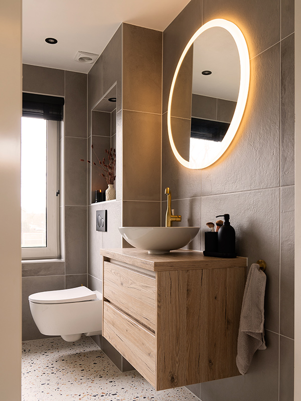 Badkamer met ronde verlichte spiegel